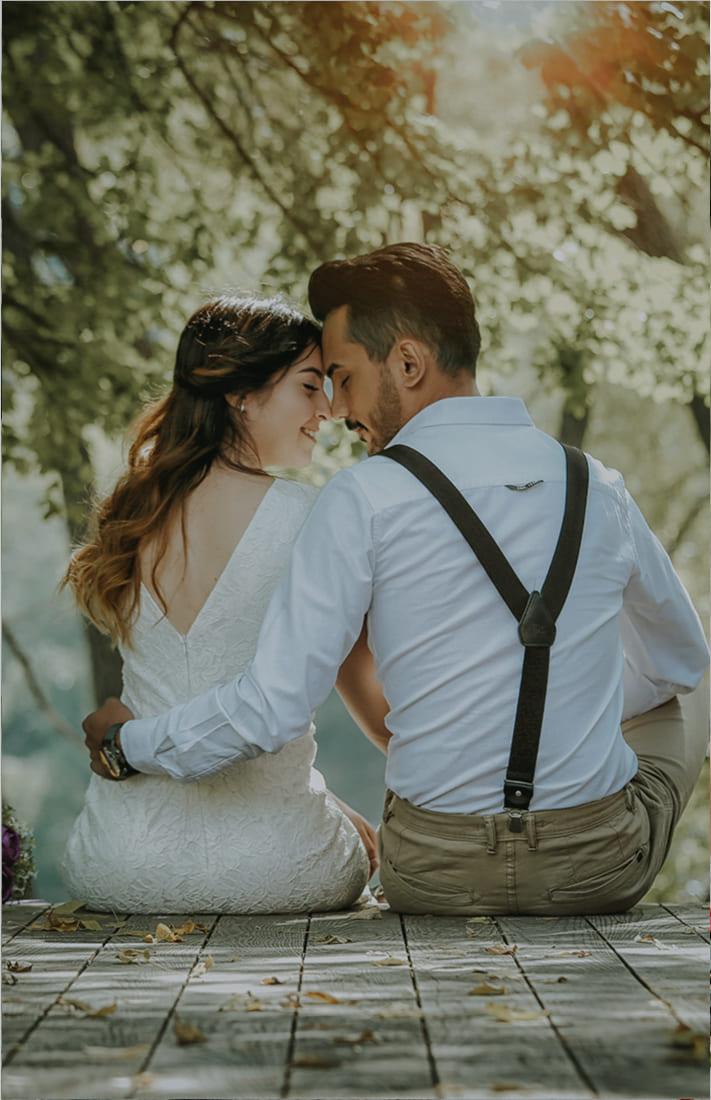 新郎と新婦が向き合って座っておでこを寄せ合っている。